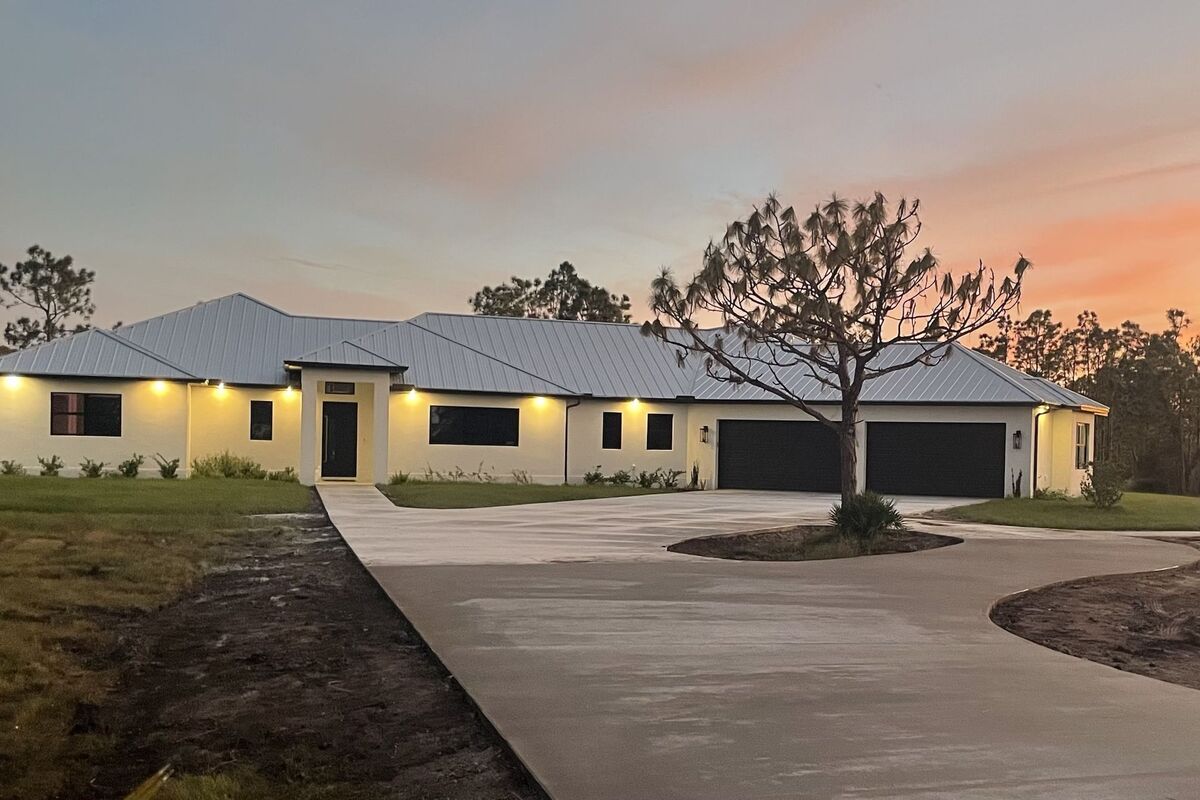 Single-story custom home at dusk with soffit lighting