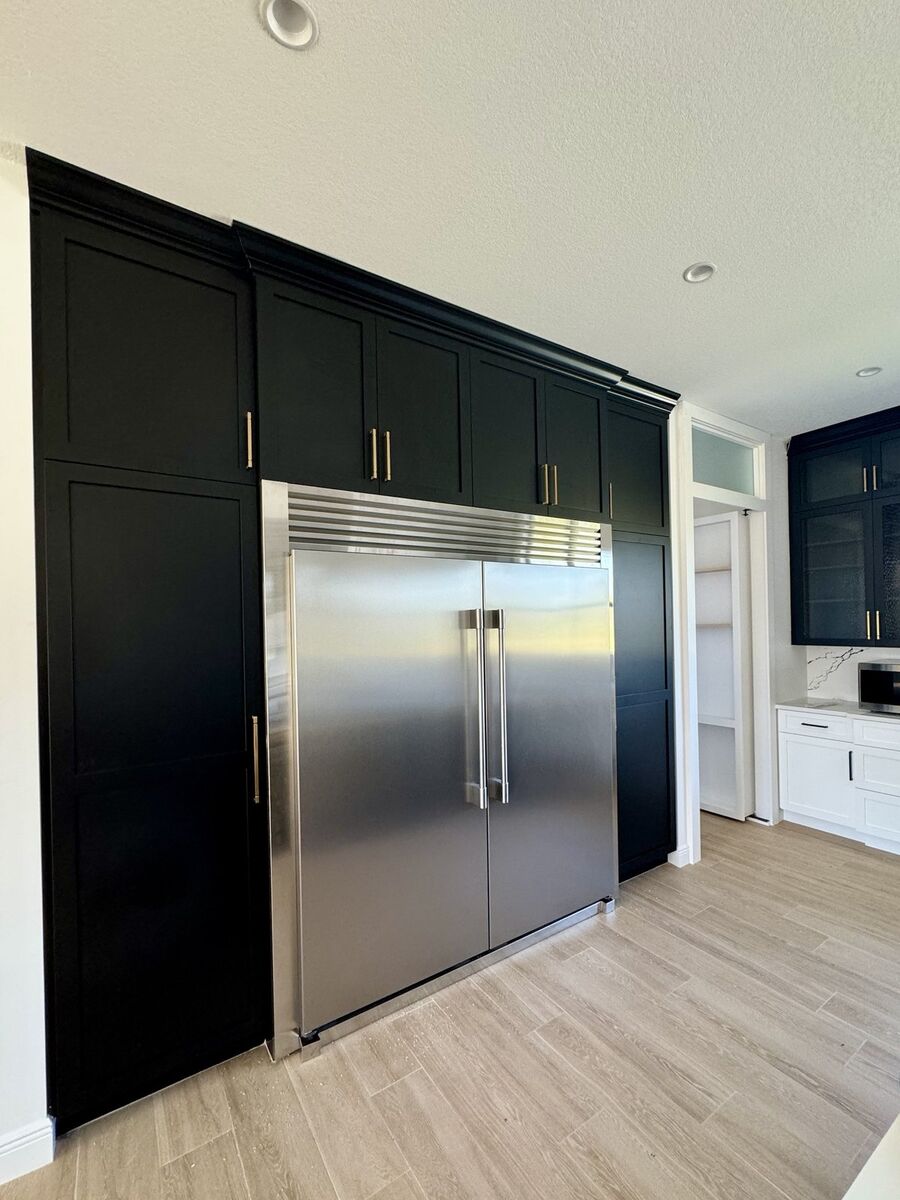 Black millwork pantry wall with integrated refrigeration