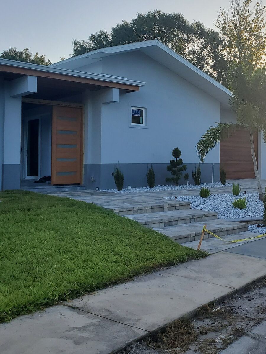 Contemporary entry with a wood door and white stone landscaping