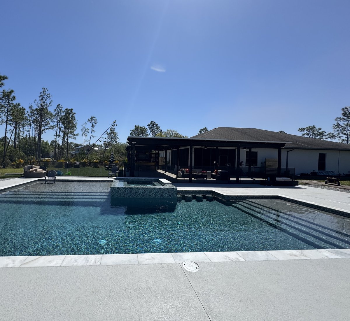 Pool with glass-tile spa and a covered lanai with outdoor kitchen