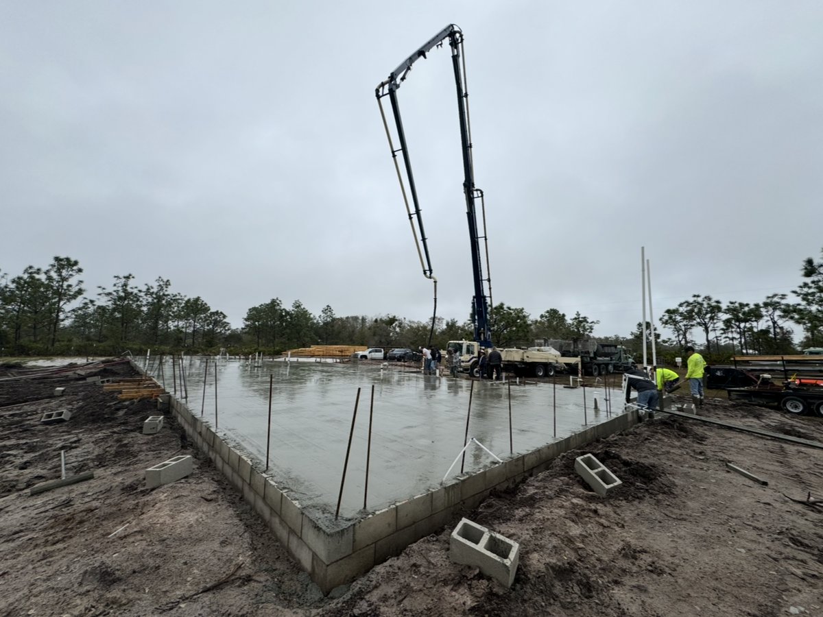 Monolithic slab being poured by concrete pump on a Bradenton lot